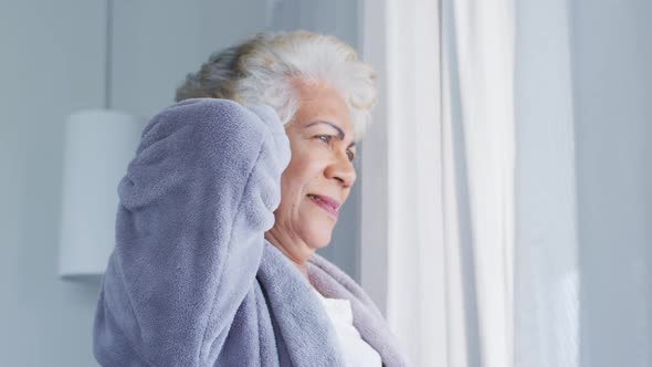 Thoughtful african american senior woman sitting on the bed at home alt