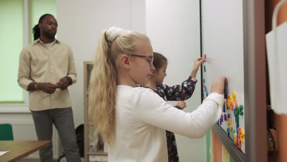 African American Teacher Teaches Children English Using a Magnetic Board
