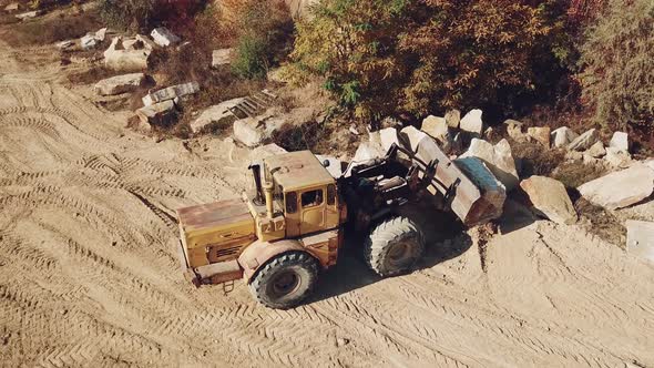 Specially Equipped Machine With a Bucket id Working Near a Quarry With Stones alt