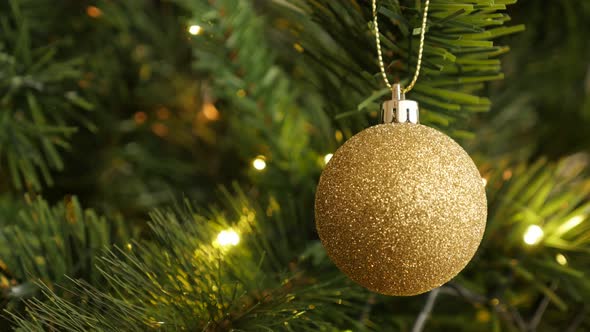 Golden decorative bauble on  the Christmas tree 4K 2160p 30fps UltraHD footage - Sequins on round  o alt