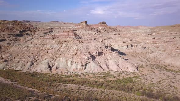 Flying through river bottom with foliage to rocky dry desert landscape alt