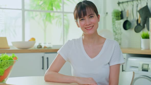 Portrait of beautiful mature woman smile and look at camera in kitchen enjoy morning weekend. alt