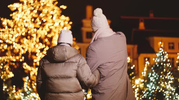 Couple Walking in City Over Christmas Lights