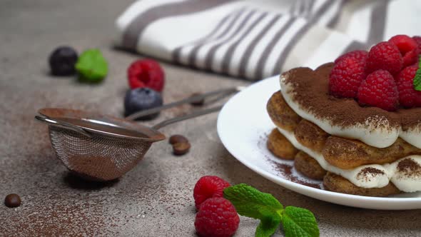 Portion of Classic Tiramisu Dessert with Raspberries on Grey Concrete Background alt