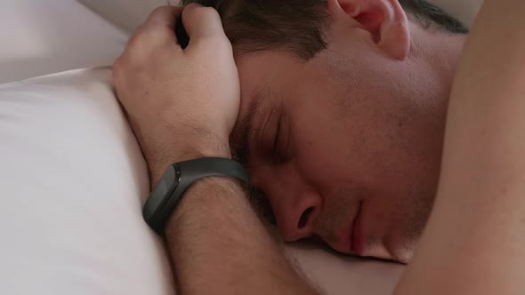 Tired Man with Naked Body Lies on the Bed at Home and Rests After Hard Day Work alt