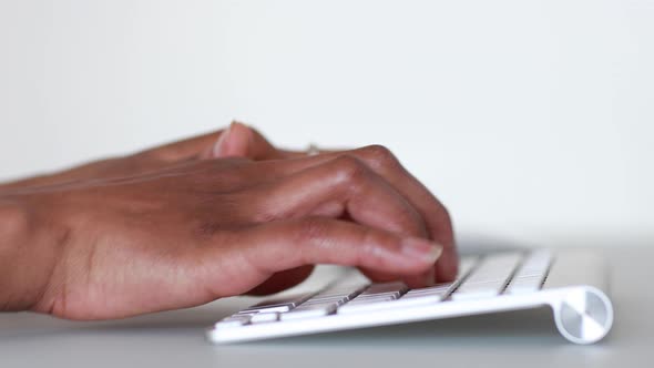 African American person typing on a laptop keyboard- Black people