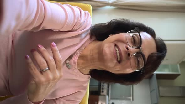 Woman Talking and Waving Hand in Front of Screen During Online Call at Home Room alt