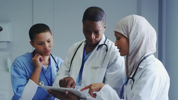 Front view of Multi-Ethnic doctors discussing over medical report in hospital alt