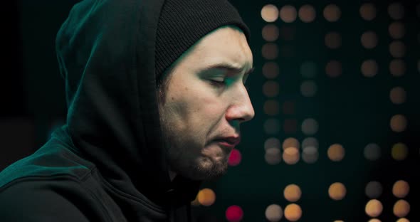Close Up of Hacker Wearing a Hoodie Tries to Hack a Security System to Steal alt