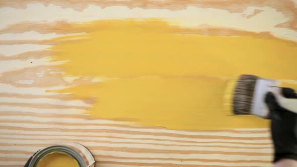 Time-lapse. Paint in metal paint can and painters tools on a wood board alt