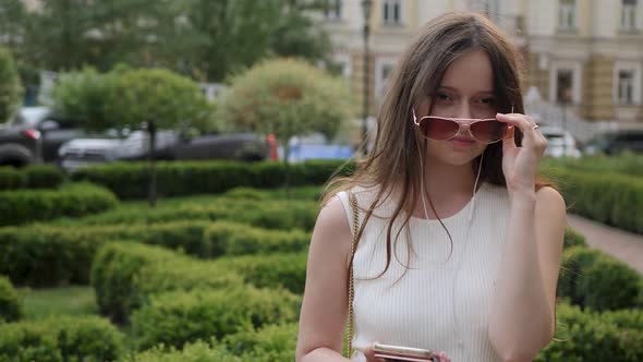 Young Woman Takes Off Sunglasses