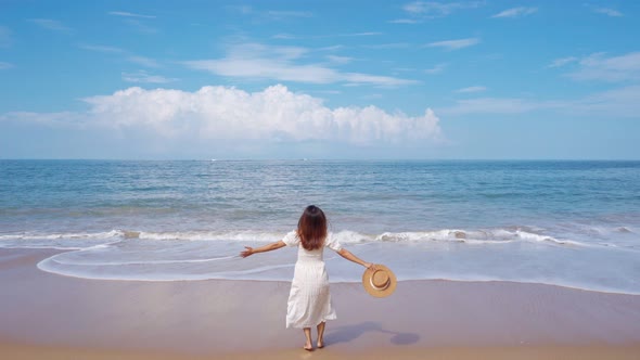 Young woman traveler enjoying at beautiful tropical white sand beach