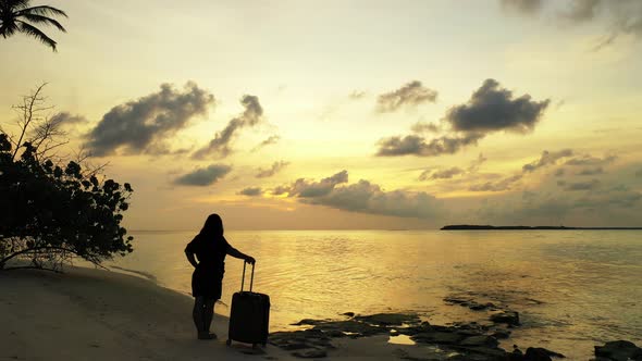 Young smiling girl on vacation having fun at the beach on clean white sand and blue  alt