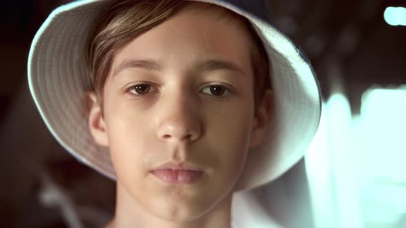 Portrait of a Sad Serious Boy in Hat Looking at the Camera Cinematic Shot