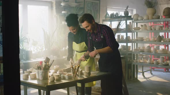 Couple Is Working With Clay In Pottery Workshop
