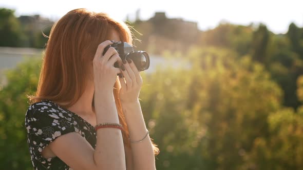 Smiling Ginger Girl in Black and White Dress Shooting with Film Camera in Slowmotion alt