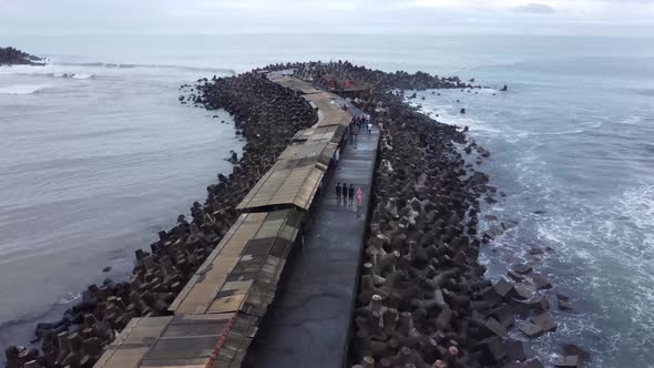 Aerial view of sea wave crashing tetra concrete block or wave breaker stone at Glagah beach, Indones alt