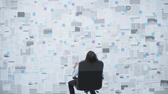 Businesswoman swinging on a chair and checking financial data