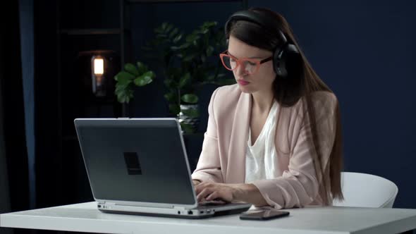 Serious Focused Business Woman with Headphones Using Laptop During Video Call alt