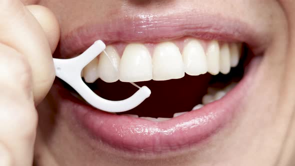 close up4 k video woman mouth smiling and flossing her teeth with white plastic toothpick. beautiful alt