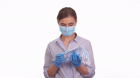 Woman showing sterile medical mask, COVID-19 pandemic