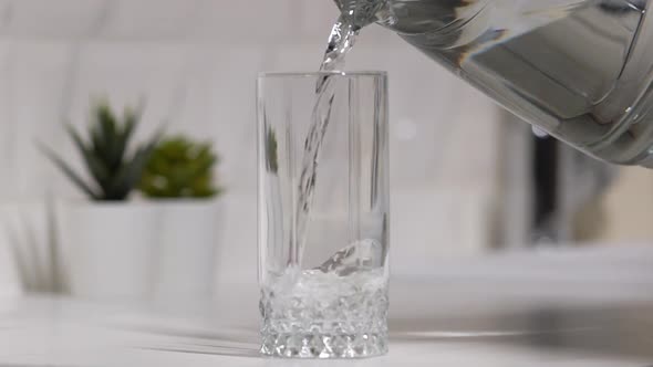 Pouring Clean Water From a Carafe Into a Glass