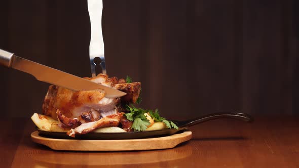 A Man's Hand Cuts an Appetizing Meat Dish Into the Bone with a Knife. Ready Meat Dish with Garnish
