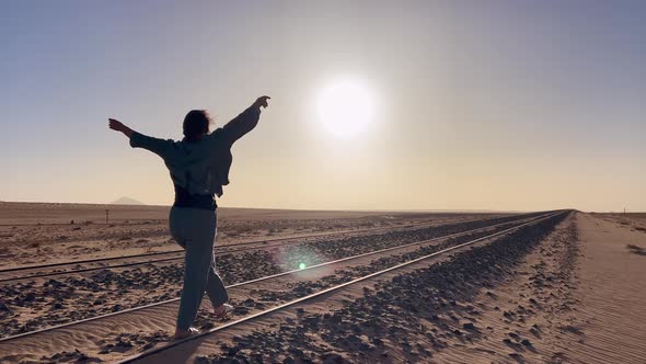 Young Woman Walks at Abandoned Railway Near Garub Railroad Station alt