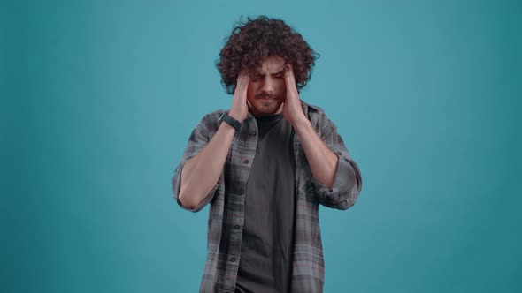 The Tired Stressed Young Man Massages His Forehead with Both Hands Frowns and Breathes Tired alt