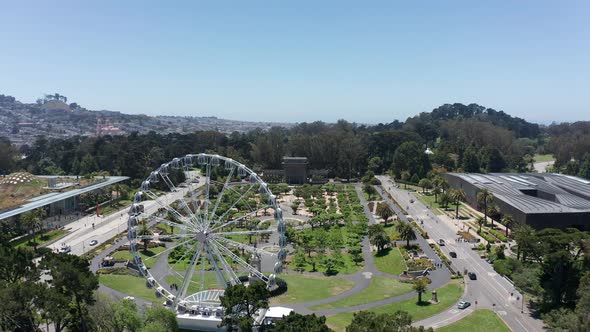 Aerial shot flying by the SkyStar Ferris Wheel towards the Spreckles Temple of Music bandshell in th alt