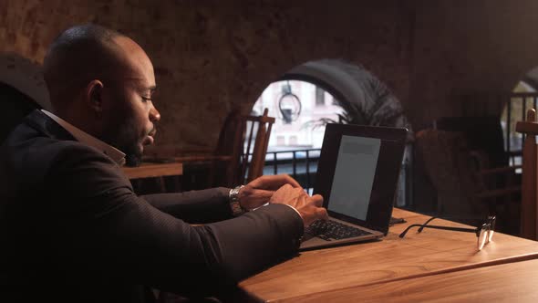 Black Businessman Using Laptop for Analyzing Data Stock Market Stock Exchange Trading Online alt