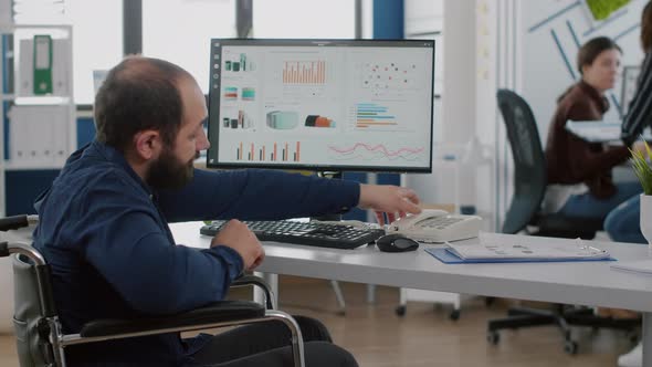 Busy Paralysed Handicapped Team Leader Answering Phone Talking with Partner alt