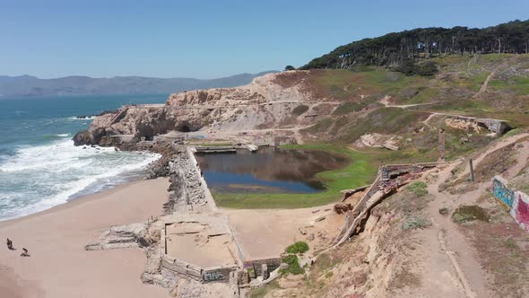 Close-up descending and panning aerial shot of the ruins of the Sutro Baths at Land's End in San Fra alt