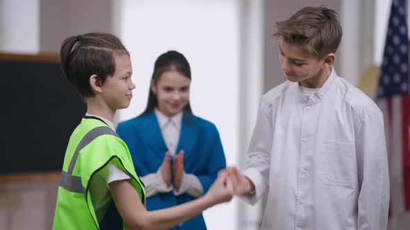 Teenage Caucasian Boys Making Pinky Swear Gesture Shaking Little Fingers Smiling As Cheerful Girl alt