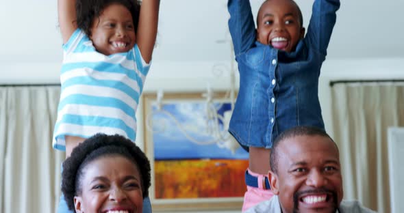 Kids and parents cheering while watching match on television in living room alt