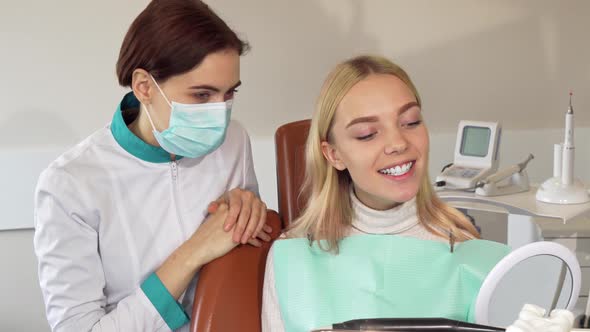 Professional Dentist and Her Patient Smiling To the Camera alt