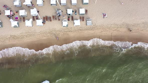 AERIAL: Top Shot of Waving White Tents and Flags on a Sandy Beach nera Baltic Sea