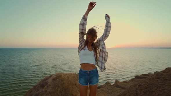 Back View Brunette Blowing Hair Woman Walking By Hill Top with the Panoramic View at Sunset alt