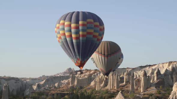 Colourful Hot Air Balloons with Large Baskets Fly in Line alt