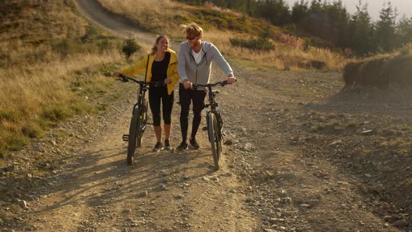 Girl and Guy with Bikes Going on Road Cyclists Taking Rest After Exercising alt
