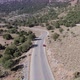Following car Aerial view from above on the country road in mountain range between rocks and trees - VideoHive Item for Sale