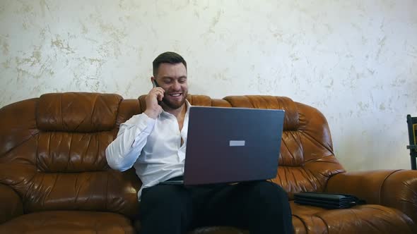 Relaxed businessman is working in a hotel room on laptop alt