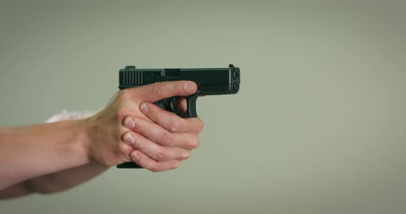Closeup of the Hand of a Shooting Instructor Aiming and Firing a Shot at a Target on an Indoor alt