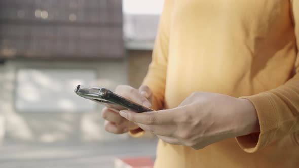 Asian tourist blogger woman using touchscreen technology at smartphone while walking.