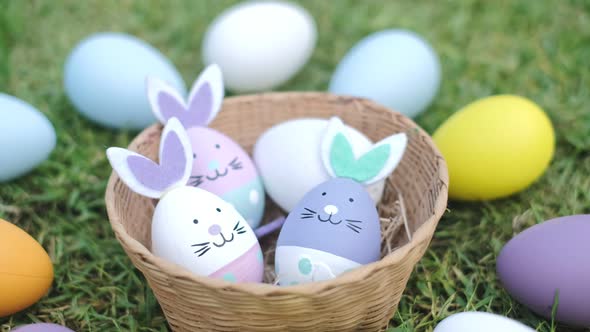 Easter bunny ornaments in nest and Easter Eggs on lawn grass