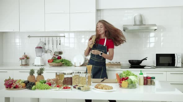 The young woman entered the kitchen, made the meal and danced in joy, fun in the routine alt
