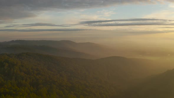 Slow reveal above Olinda, Victoria, Australia township with stunning afternoon light pouring through alt