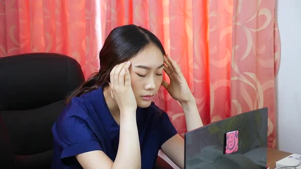 woman sitting at home working She felt migraine even when working.