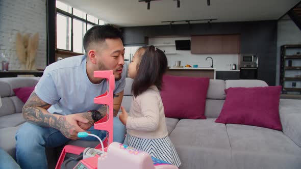 Caring Asian Dad Babysitting Toddler Daughter at Home alt