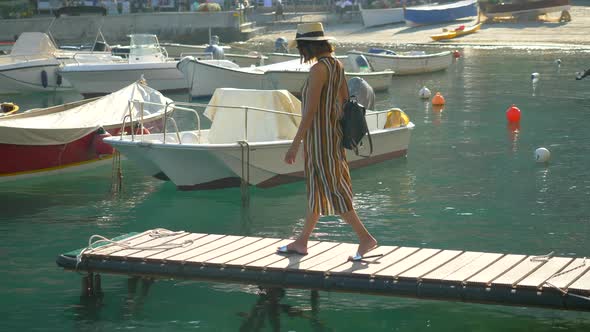 A woman on a boat dock in Portofino, Italy, a luxury resort town in Europe alt